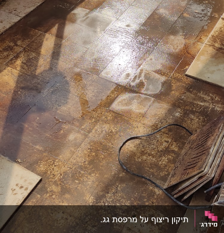 רצפה רטובה עם אריחים מוסרים בתהליך שיפוץ